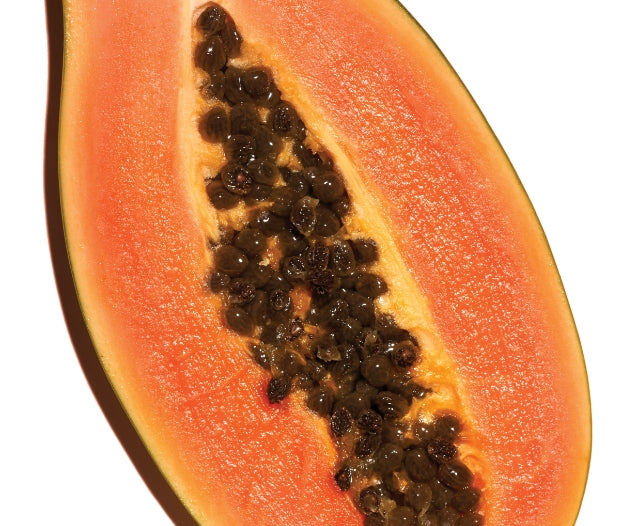 An open papaya with seeds inside on a white background